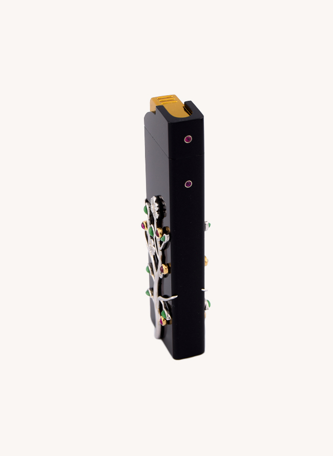 Fumoir Prunus lighter seen at an angle, the jewelled prunus branch wrapping the black jade body
