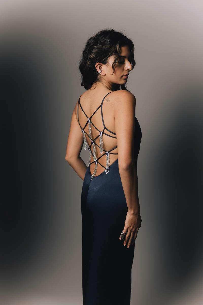 Back view of a navy gown with crossed straps and jewelled chain tassels